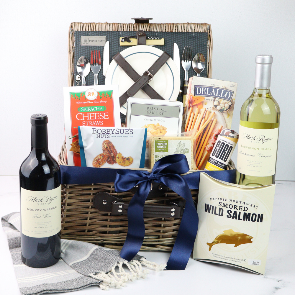 Gift basket with wine, smoked salmon, and assorted snacks on a white background