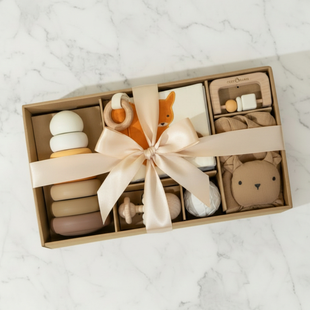 Gift set with baby toys and a bow on a marble surface