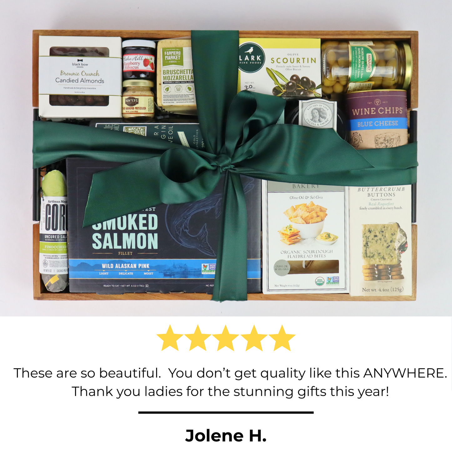Gourmet gift basket with green ribbon, smoked salmon, chocolates, and artisan snacks – perfect corporate gift idea.