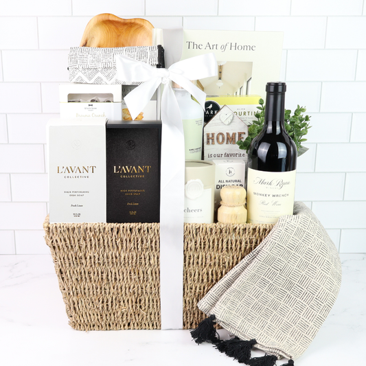 Gift basket with wine, candles, and other items on a white background